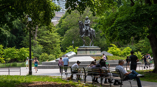 People sitting on benches in Queen's Park