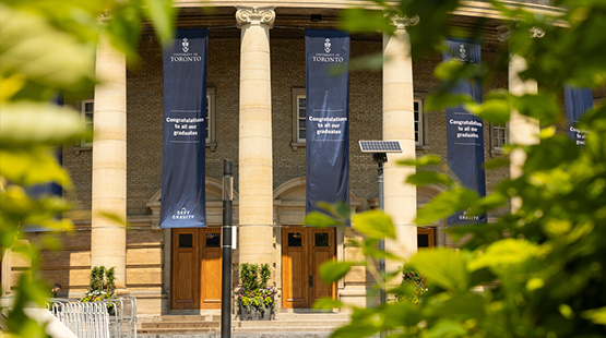 The exterior of Convocation Hall with banners and green trees
