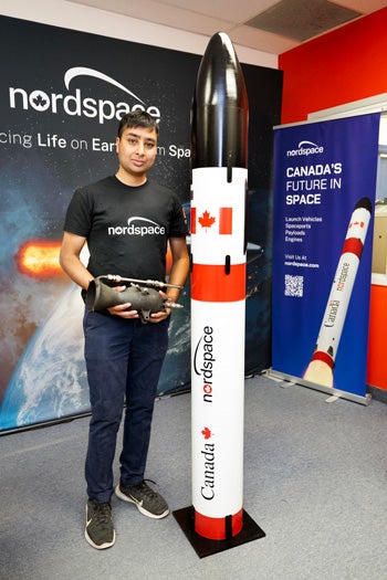 Rahul Goel stand beside a model of the Nordstream rocket