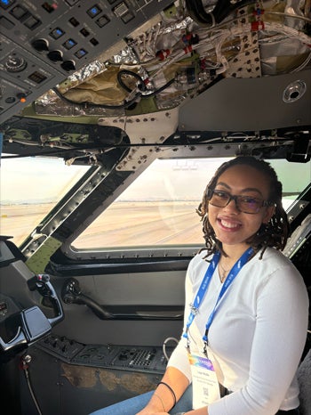 Leah wolfe sits in an airplane cockpit