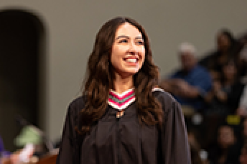 A graduate walks across the stage at Convocation Hall