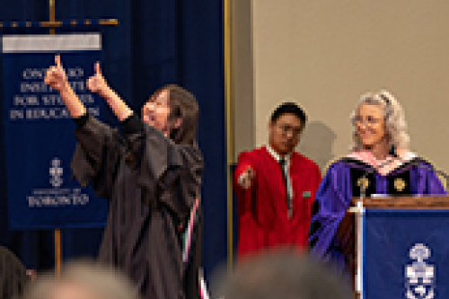 A graduate gives thumbs up to the crowd during the ceremony