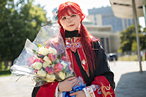 A student holds a bouquet of flowers