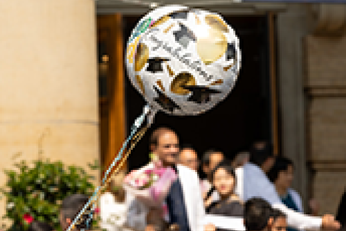 A balloon with graduation text floats outside