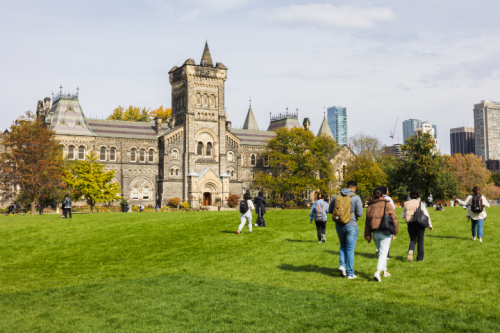 People walk across the grass on front campus
