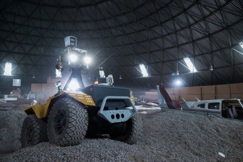 A small rover with four wheels in a dome with lights