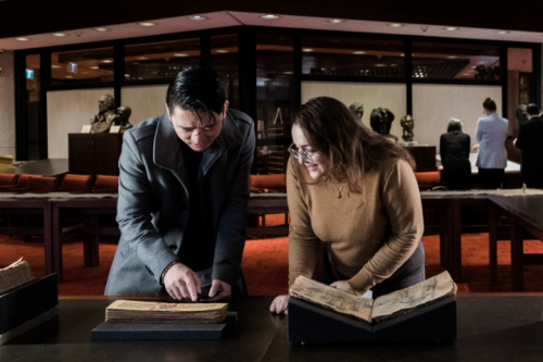 Two people look at old books in the Thomas Fisher Rare Book Library