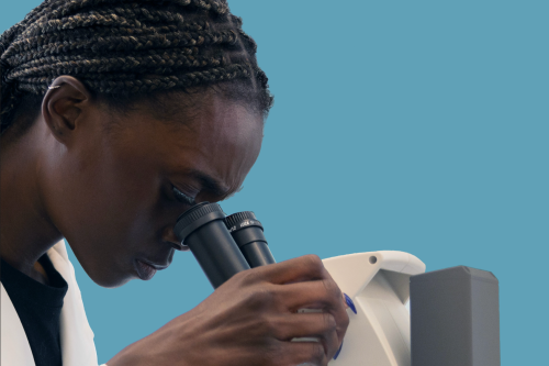 A researcher looks into a microscope