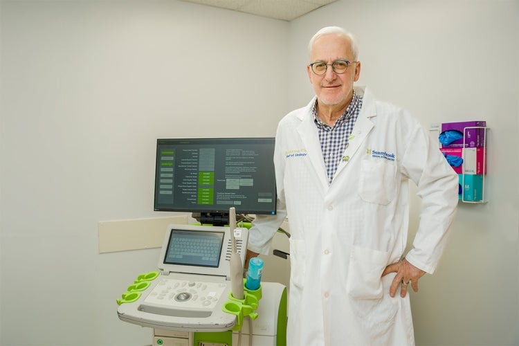 Laurence Klotz stands beside the ultrasound machine
