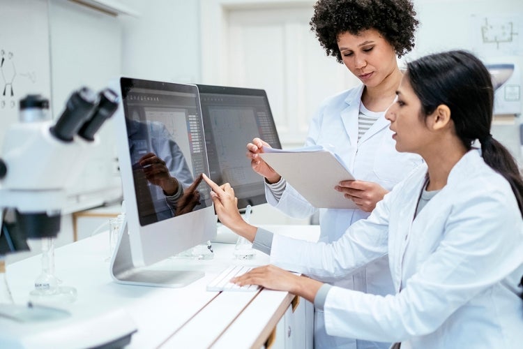 female doctors collaborate in front of computer screens