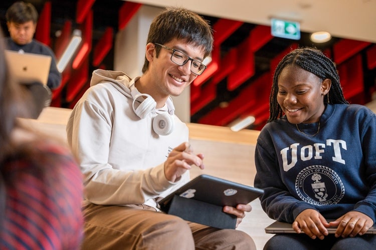 two students looking at an ipad together