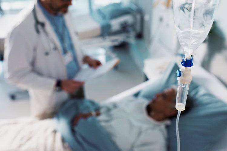 doctor and patient in the background with an iv bag in the foreground
