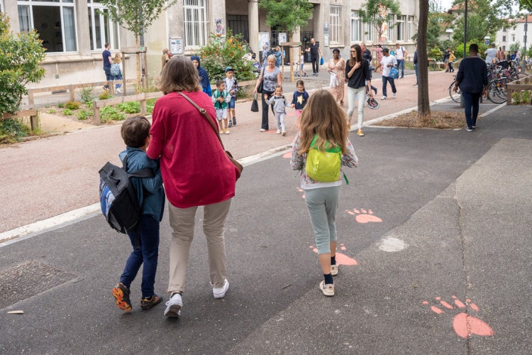 parents and children walk to school on a car-free street