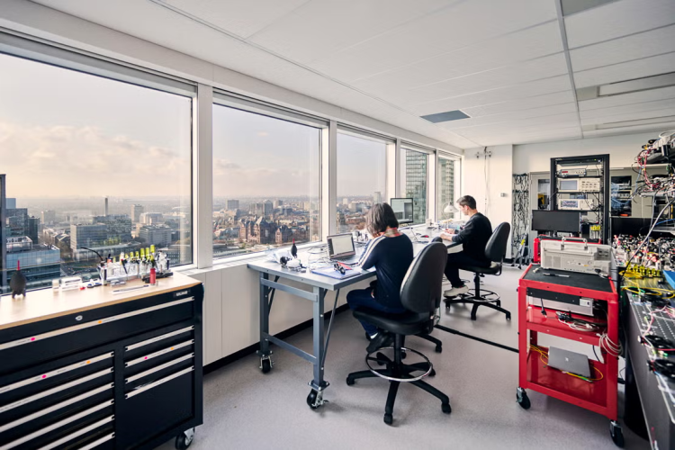 toronto skyline seen from Xanadu offices with people working at workshop benches in the foreground
