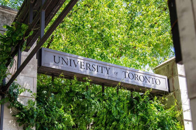 A U of T sign with a green, leafy tree in the background