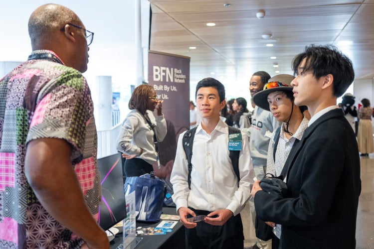Acceleratorfest attendees interact with a staff member at the Black Founders Network booth