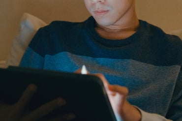 young man typing on a tablet while at home