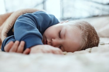 two year old child sleeps on a mattress