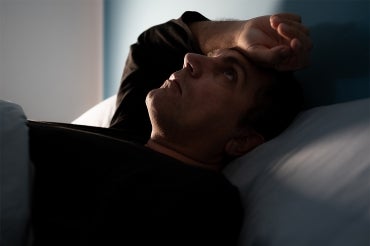 a man laying awake in bed