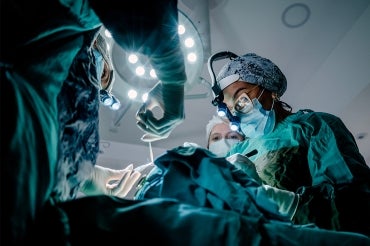 a team of three surgeons working on a patient