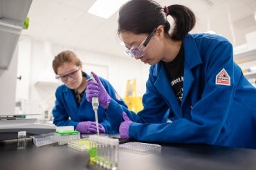 Caitlin Maikawa and Lucia Huang are seen working in a lab