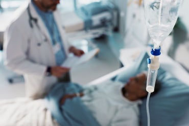 doctor and patient in the background with an iv bag in the foreground