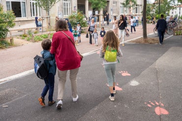 parents and children walk to school on a car-free street