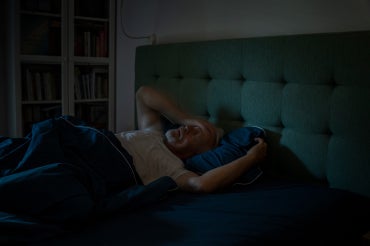 older man having trouble sleeping in bed