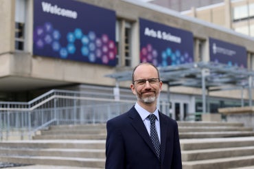 Stephen Wright stands in front of Sidney Smith Commons on the St. George campus