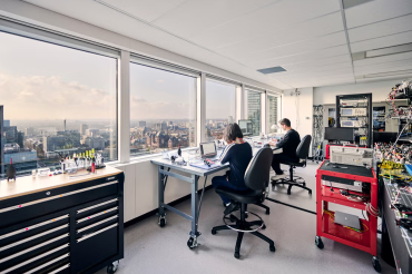 toronto skyline seen from Xanadu offices with people working at workshop benches in the foreground