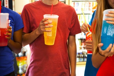 teens drinking soda pop in a variety store(