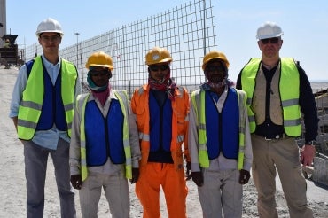Adam Sheikh and workers demonstrate the cooling vests