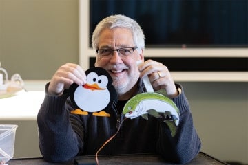 Dietz holds up animatronic paper cutouts