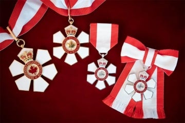 Medals for the various levels of the order of canada displayed on a table