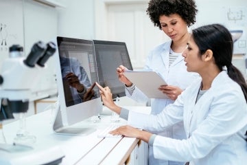 female doctors collaborate in front of computer screens