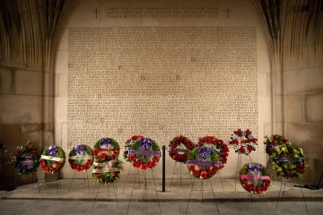 wreaths are laid by the wall of names of fallen soldiers and soldiers tower