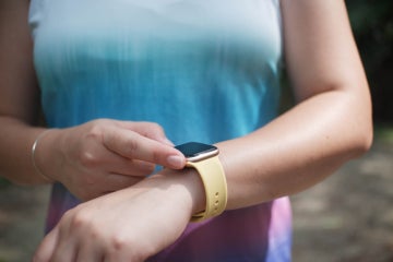 woman in athletic gear checks her smartwatch