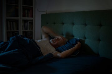 older man having trouble sleeping in bed