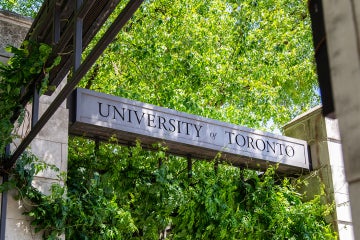 A U of T sign with a green, leafy tree in the background