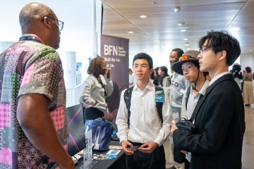 Acceleratorfest attendees interact with a staff member at the Black Founders Network booth