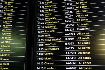 Photo of a flight information board at an airport showing a cancelled flight to Shanghai