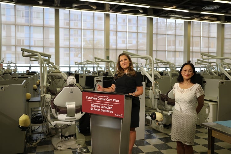 Freeland speaks at a podium that says "Canadian Dental Care Plan"