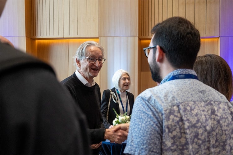 Hinton speaks to someone during his Nobel celebration event