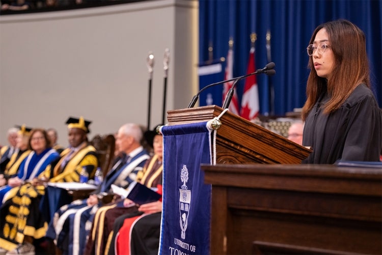 Sydelle Mago speaks at a lecture in Convocation Hall as Wes Hall looks on
