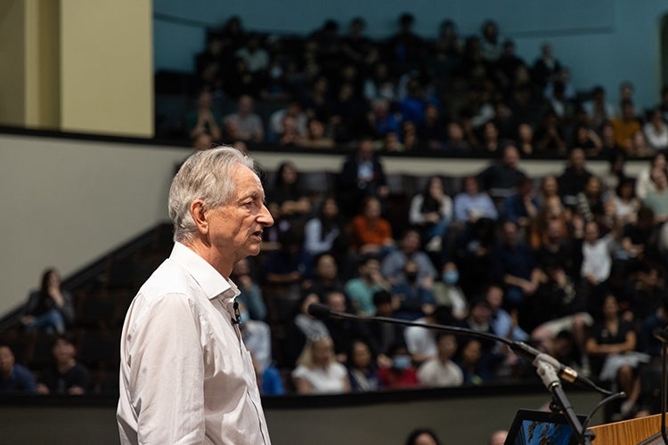 Hinton at the podium inside convocation hall at the university of toronto