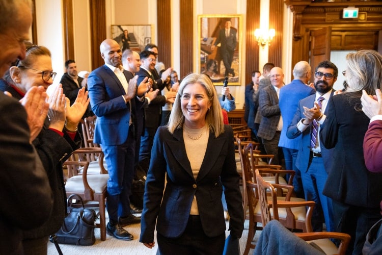 Woodin is applauded as she walks through Governing Council Chamber in Simcoe Hall on the St. George campus.