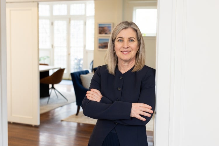 Melanie Woodin leans against the doorframe in an office.