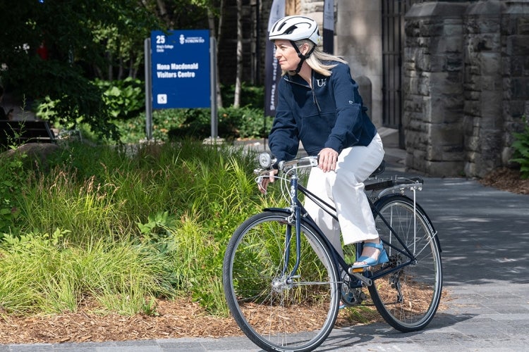 President woodin rides her bike on kings college circle