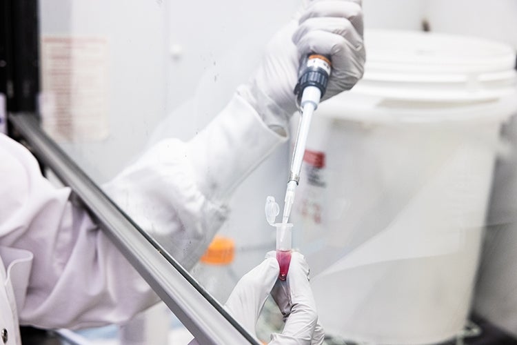 A research works under a protective hood in Daniel Druckers Sinai Health lab