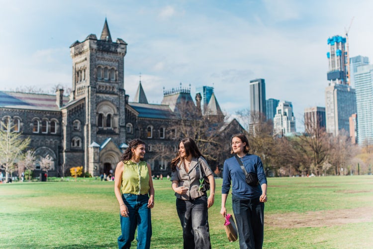 three students walk on front campus at the University of Toronto